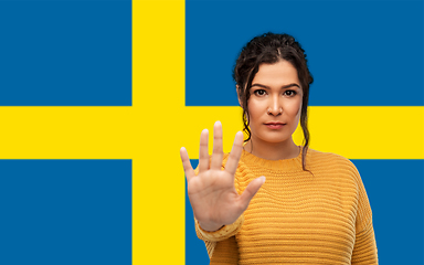 Image showing woman showing stop gesture over flag of sweden