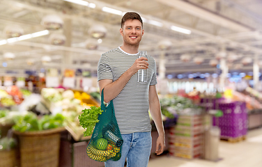 Image showing man with food in bag and water in glass bottle