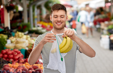 Image showing man with bananas and string bag at street market