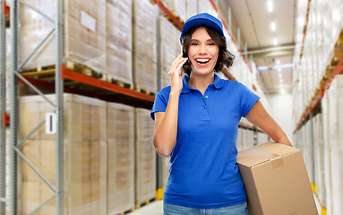 Image showing delivery girl with parcel box calls on smartphone