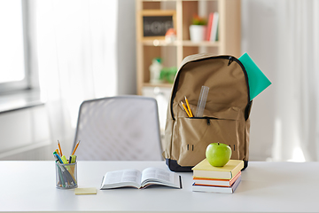 Image showing books, apple and school supplies on table at home