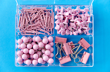 Image showing pins and clips in plastic pox on blue background