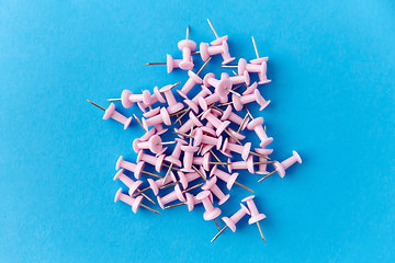 Image showing heap of pink office pins on blue background