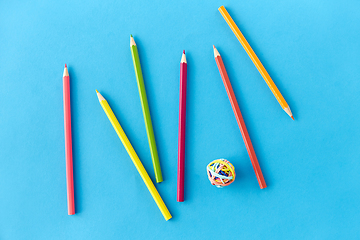 Image showing coloring pencils and rubber bands on blue