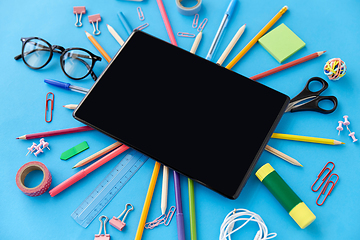 Image showing tablet pc and school supplies on blue background