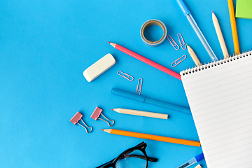 Image showing notebook and school supplies on blue background