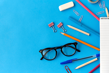 Image showing notebook and school supplies on blue background