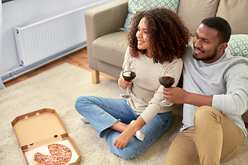 Image showing happy couple with wine and takeaway pizza at home