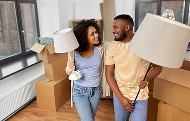 Image showing happy couple packing boxes and moving to new home