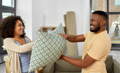 Image showing happy couple having pillow fight at new home