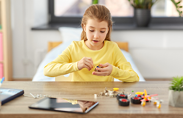 Image showing happy girl playing with robotics kit at home