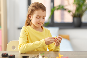 Image showing happy girl playing with robotics kit at home