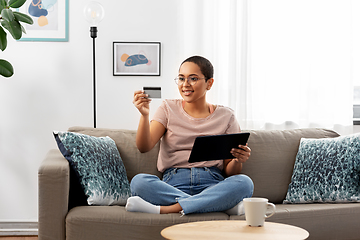 Image showing happy woman with tablet pc and credit card at home