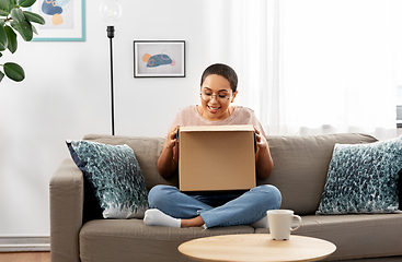 Image showing african american woman opening parcel box at home