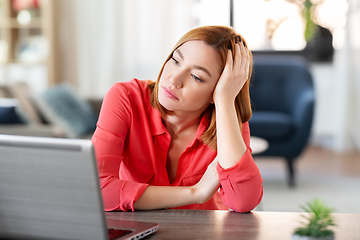 Image showing bored woman with laptop working at home office