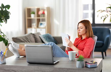 Image showing sad woman with notebook and laptop at home office