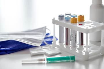 Image showing beakers with coronavirus blood tests and syringe