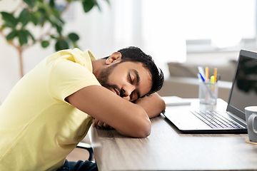 Image showing indian man sleeping on table with laptop at home