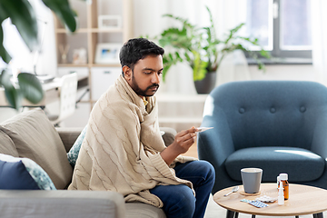 Image showing sick man measuring temperature by thermometer