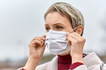 Image showing young woman wearing protective medical mask