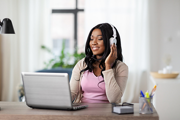 Image showing woman in headphones with laptop working at home