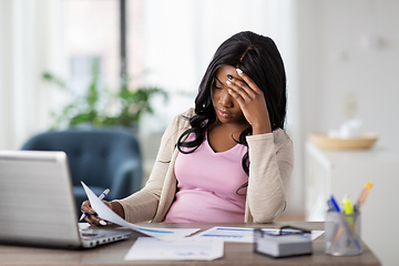 Image showing stressed woman with papers working at home office