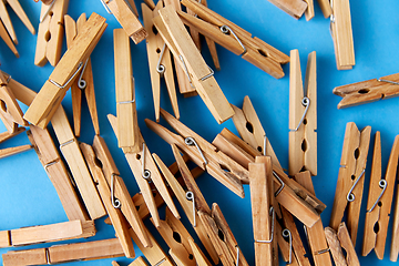 Image showing close up of wooden clothespins on blue background