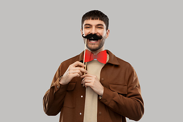 Image showing smiling man with mustache and bowtie party props