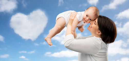 Image showing happy middle-aged mother with baby over sky