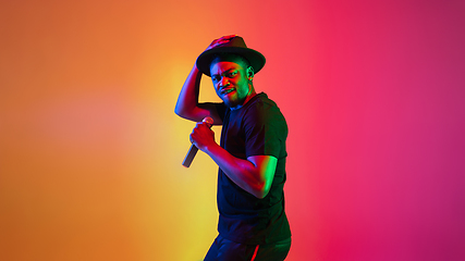 Image showing Young african-american musician singing, dancing in neon light