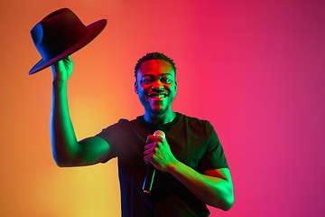 Image showing Young african-american musician singing, dancing in neon light