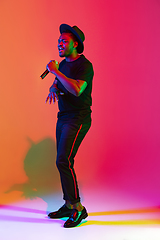 Image showing Young african-american musician singing, dancing in neon light