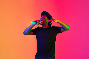 Image showing Young african-american musician singing, dancing in neon light