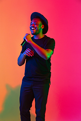 Image showing Young african-american musician singing, dancing in neon light