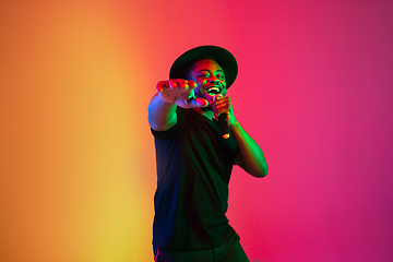 Image showing Young african-american musician singing, dancing in neon light