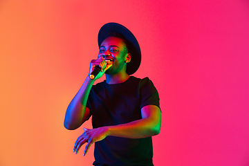 Image showing Young african-american musician singing, dancing in neon light