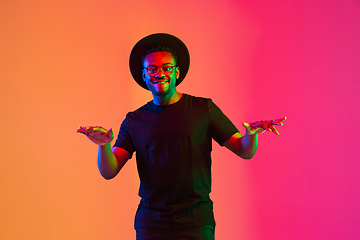 Image showing Young african-american musician singing, dancing in neon light