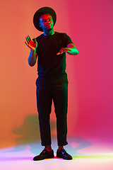 Image showing Young african-american musician singing, dancing in neon light