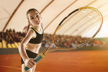 Image showing Little caucasian girl playing tennis on sport court background
