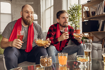 Image showing Excited, happy friends watch sport match together on the couch at home