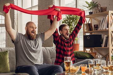 Image showing Excited, happy friends watch sport match together on the couch at home