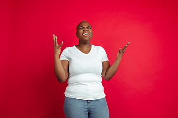 Image showing African-american young woman\'s portrait on red background