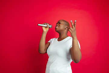 Image showing African-american young woman\'s portrait on red background