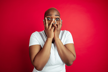 Image showing African-american young woman\'s portrait on red background