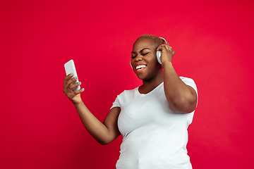 Image showing African-american young woman\'s portrait on red background