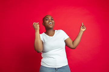 Image showing African-american young woman\'s portrait on red background