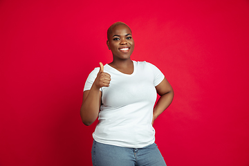 Image showing African-american young woman\'s portrait on red background