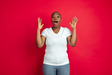 Image showing African-american young woman\'s portrait on red background