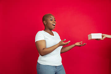 Image showing African-american young woman\'s portrait on red background