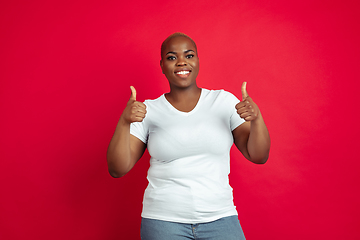 Image showing African-american young woman\'s portrait on red background